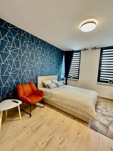 ein Schlafzimmer mit einem Bett und einem Stuhl in der Unterkunft Apartamenty 1 maja 94 Katowice, Free Parking in Kattowitz