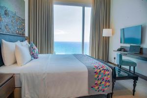 a hotel room with a large bed and a large window at Sofia Colombo City Hotel in Colombo