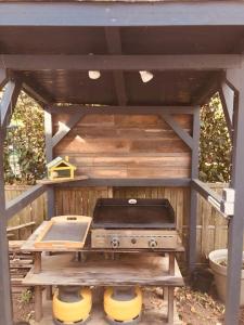 a picnic table with a stove in a wooden structure at Villa vacance Anglet avec piscine, 1km de la plage in Anglet