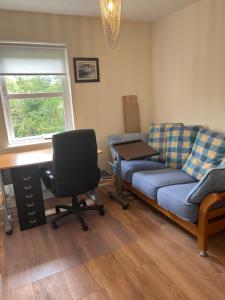 un soggiorno con divano e scrivania di 15 Cluain Caoin Nenagh a Nenagh