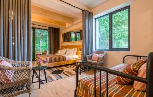 una camera da letto con un letto, un divano e finestre di 1740 Boutique Hotel Kazbegi a Kazbegi