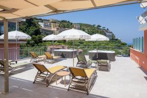 a patio with chairs and tables and umbrellas on a roof at Futura Funky House - De Vivo Realty Sorrento in Sorrento
