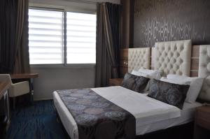 a hotel room with a bed with a window and a window at Orty Airport Hotel in Izmir