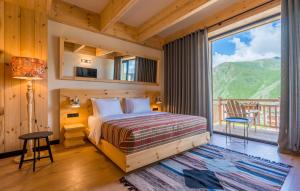 una camera da letto con un letto e una grande finestra di 1740 Boutique Hotel Kazbegi a Kazbegi