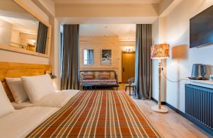 una camera d'albergo con un letto e un divano di 1740 Boutique Hotel Kazbegi a Kazbegi Altre 37 foto