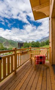 una veranda in legno con panchina sul ponte di 1740 Boutique Hotel Kazbegi a Kazbegi