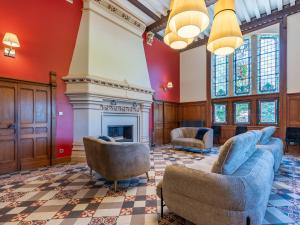 un soggiorno con due sedie e un camino di Cottage de Montchamp a Châtenay