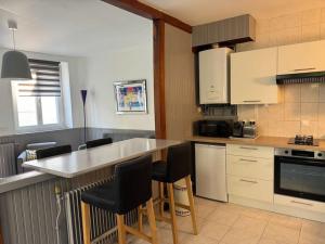 a kitchen with a counter and some chairs in it at La Maison de la Cour in Avon +1 photo