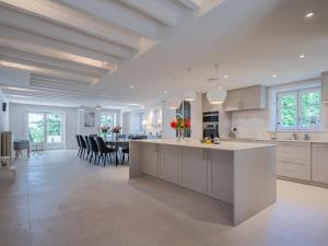 una cucina con armadi bianchi e una sala da pranzo di Cottage de Montchamp a Châtenay