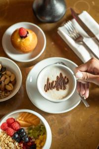 a table with plates of food and a cup of coffee at DuoMo Hotel in Rimini