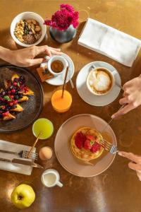 a table topped with plates of food and cups of coffee at DuoMo Hotel in Rimini