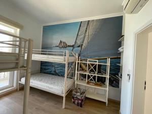 a room with two bunk beds with a mural of a sailboat at Olympia Sozopol in Sozopol +8 photos