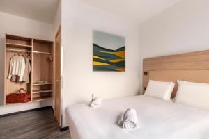 1 dormitorio con cama blanca y armario en B&B Hotel Pomezia Roma, en Pomezia