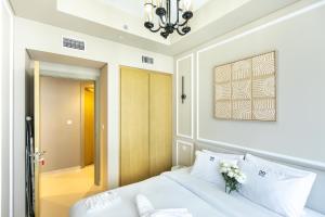 a bedroom with a white bed and a chandelier at Cozy 1 BR apartment in Dubai near Burj khalifa in Dubai