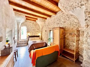 a bedroom with a bed in a stone building at Hostdomus - Fuggi nel Verde in Finale Ligure