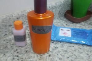 an orange bottle of shampoo next to a bottle of soap at Carnaval Inn Salvador in Salvador