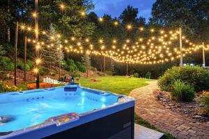 a hot tub in a yard with lights at Slide Speakeasy Movie Room Hot Tub Games Villa in Candler +74 photos