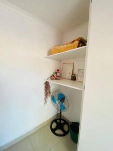 a small room with white shelves and a fan at The Fern Corner Guest House in Nkowakowa +2 photos