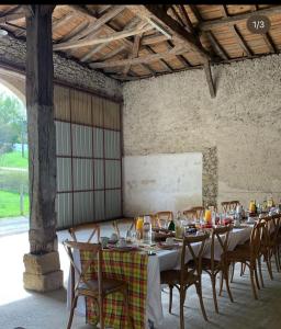 una sala da pranzo con un lungo tavolo e sedie di Le Refuge d'Alienor at Domaine Le Touran near Saint Emilion a Pellegrue