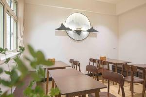 una stanza con tavoli, sedie e uno specchio di Meet Xiashu a Jincheng