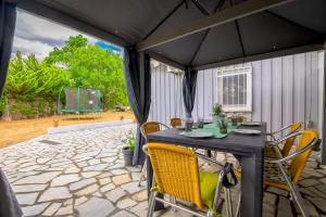 a patio with a black table and chairs at Evaggelia's Summer Resort in Dhíkella