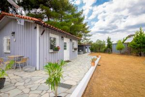 a small white house with a patio and a table at Evaggelia's Summer Resort in Dhíkella
