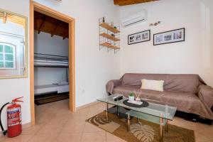 a living room with a couch and a glass table at Evaggelia's Summer Resort in Dhíkella