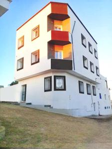 a tall white building with windows on the side of it at Résidence Maya in El Haouaria +7 photos