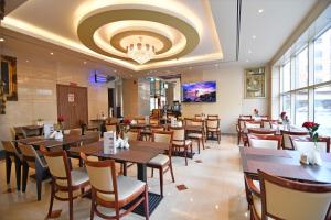 a restaurant with tables and chairs and a chandelier at Nejoum Al Emarat in Sharjah