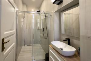 a bathroom with a glass shower and a sink at City center appartment in Pula +15 photos