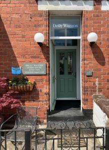 a door to a brick building with a green door at Dolly Waggon Guest House in Keswick