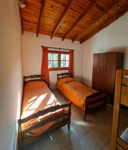 ein Schlafzimmer mit zwei Betten und einem Fenster in der Unterkunft Casa de campo in Los Hornillos