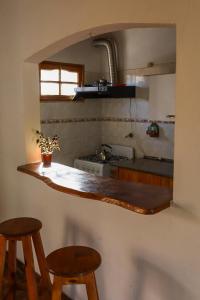 eine Küche mit zwei Hockern und einer Arbeitsplatte in der Unterkunft Casa de campo in Los Hornillos