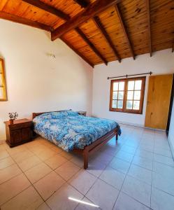 ein Schlafzimmer mit einem Bett und einer Holzdecke in der Unterkunft Casa de campo in Los Hornillos