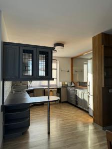 a kitchen with black cabinets and a white counter top at Tammetõru Villa in Tartu