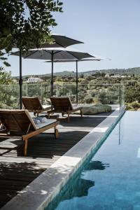 two chairs and an umbrella next to a swimming pool at Casa Kalu in São Brás de Alportel +20 photos