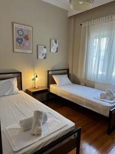 Un dormitorio con dos camas y una ventana. en KONAR Guest House, en Alexandroupoli