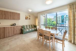 eine Küche und ein Esszimmer mit einem Tisch und einem Fenster in der Unterkunft Perla Apartments in Nessebar
