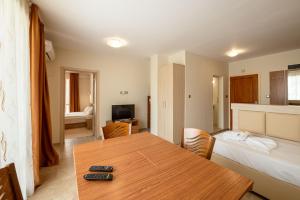 Zimmer mit einem Tisch und einem Bett sowie einem Schlafzimmer in der Unterkunft Perla Apartments in Nessebar