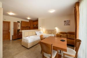 ein Schlafzimmer mit Bett und ein Esszimmer mit Tisch in der Unterkunft Perla Apartments in Nessebar + 17 Fotos