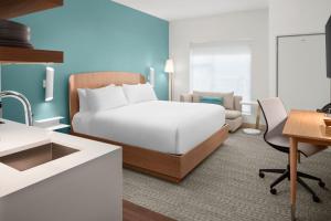a hotel room with a bed and a desk at Element by Marriott Charlotte Uptown in Charlotte