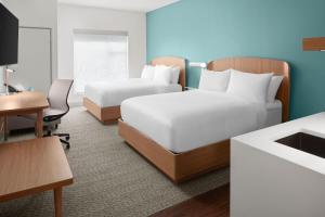 a hotel room with two beds and a desk at Element by Marriott Charlotte Uptown in Charlotte