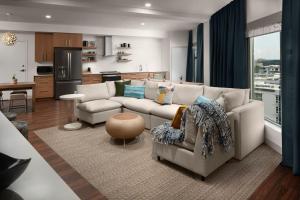 a living room with a couch and a kitchen at Element by Marriott Charlotte Uptown in Charlotte