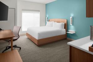 a hotel room with a bed and a desk at Element by Marriott Charlotte Uptown in Charlotte