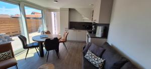 a living room with a couch and a table at 103C nieuwe vakantiewoning met sauna in Westkapelle +17 photos