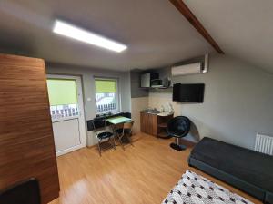 ein kleines Wohnzimmer mit einem Sofa und einem Schreibtisch in der Unterkunft Pokoje Gościnne Emilia Międzywodzie in Międzywodzie
