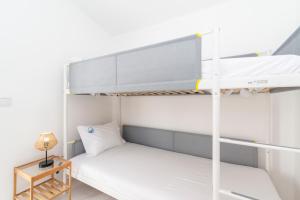 a bedroom with a bunk bed and a table at Casa Garde - 5 mins city center - private balcony - wi-fi in Tavira