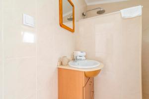 a bathroom with a sink and a mirror at Casa Garde - 5 mins city center - private balcony - wi-fi in Tavira +12 photos