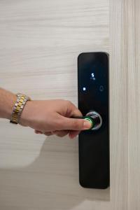 a hand is unlocking a door with a door knob at Rooftop Parthenopeo Contemporary Rooms in Naples