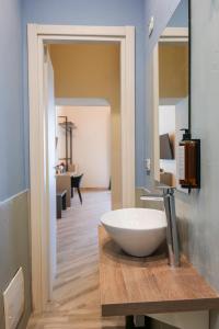 a bathroom with a bowl sink on a wooden counter at Rooftop Parthenopeo Contemporary Rooms in Naples